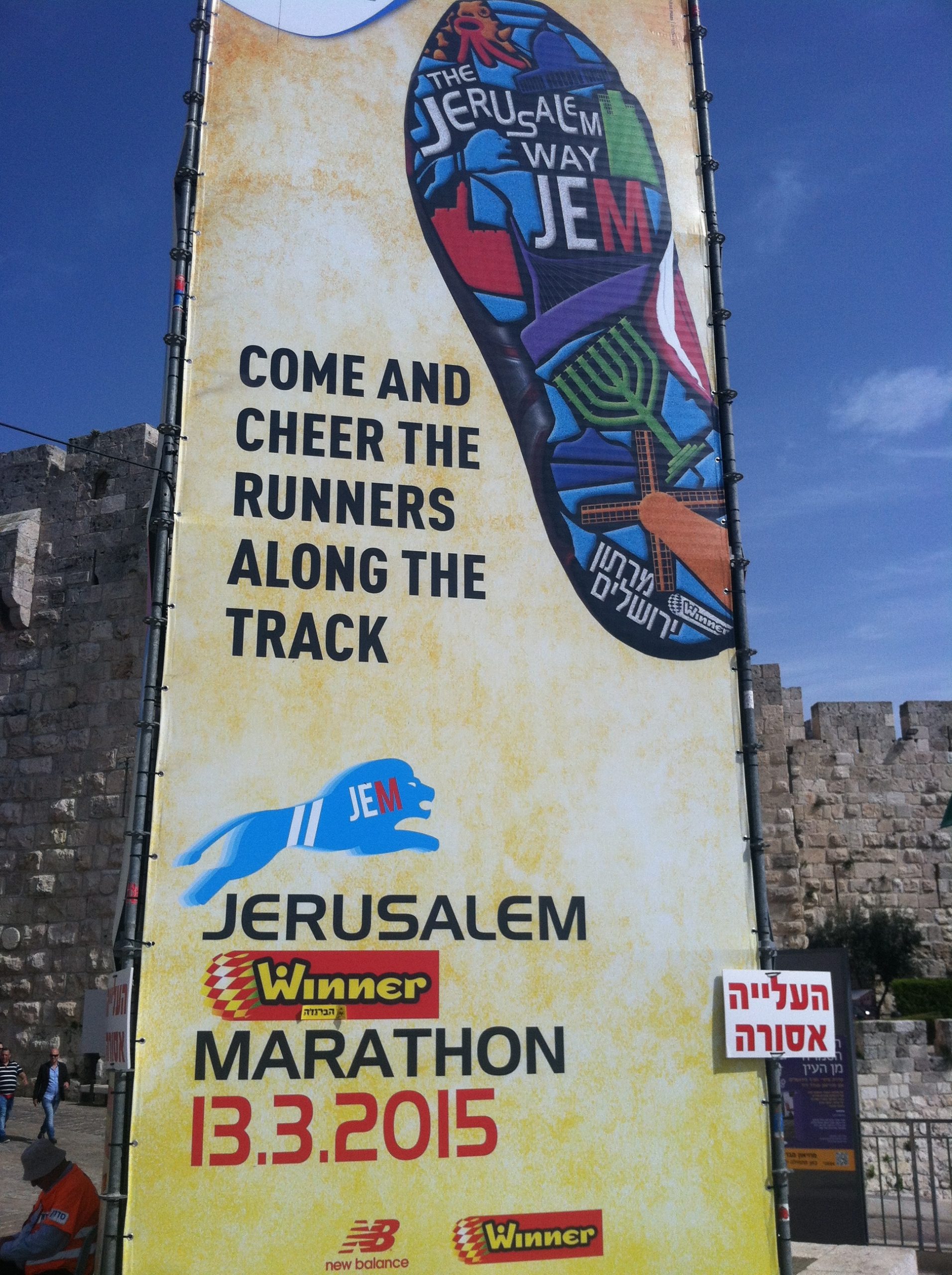 A tall sign advertising a marathon taking place in Jerusalem
