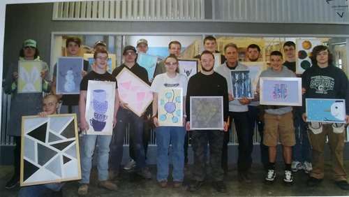 Students at the Capital Area Career Center help Hannah frame her artwork.
