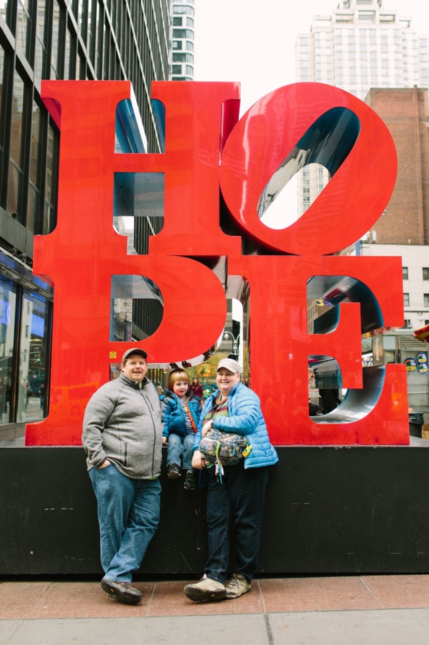 The Thomas family standing in front of the HOPE sculpture in New York City