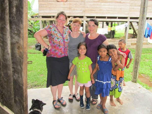 Smiling group photo of three women and four children