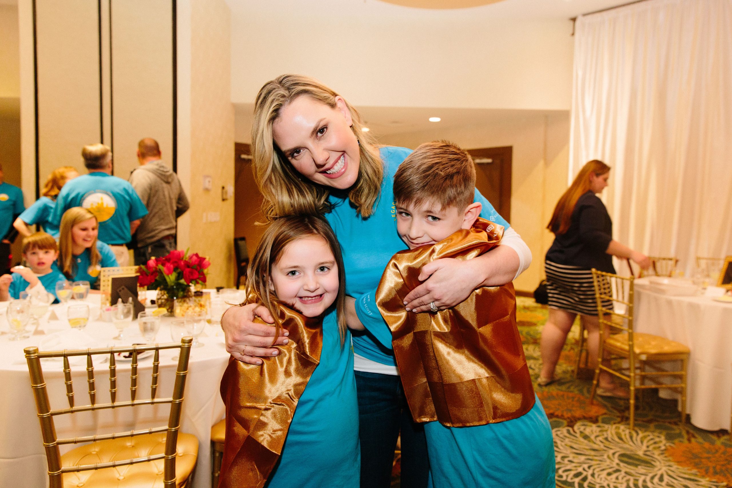 Orlando Legacy Retreat presentor Kendra Scott smiling and hugging two children