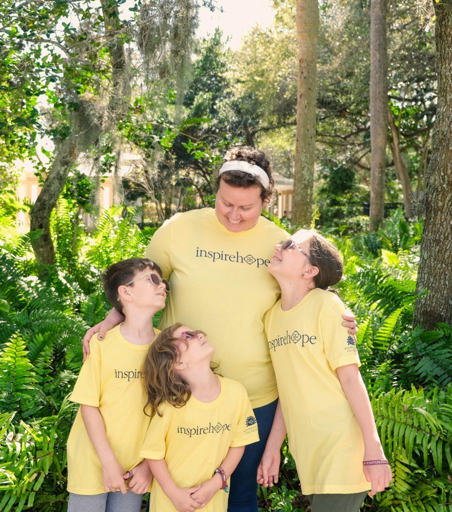 Photo of a mom being hugged by her 3 young children.