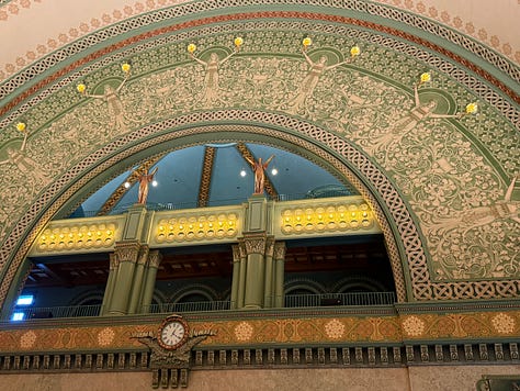 Arched ceiling with detailed green patterns and clock