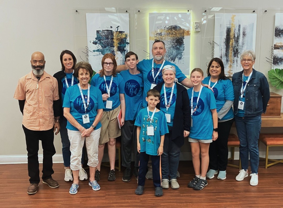 491810085_122240948498197056_8537755198839602500_n – Copy A group photo of people in blue Hope Hub shirts