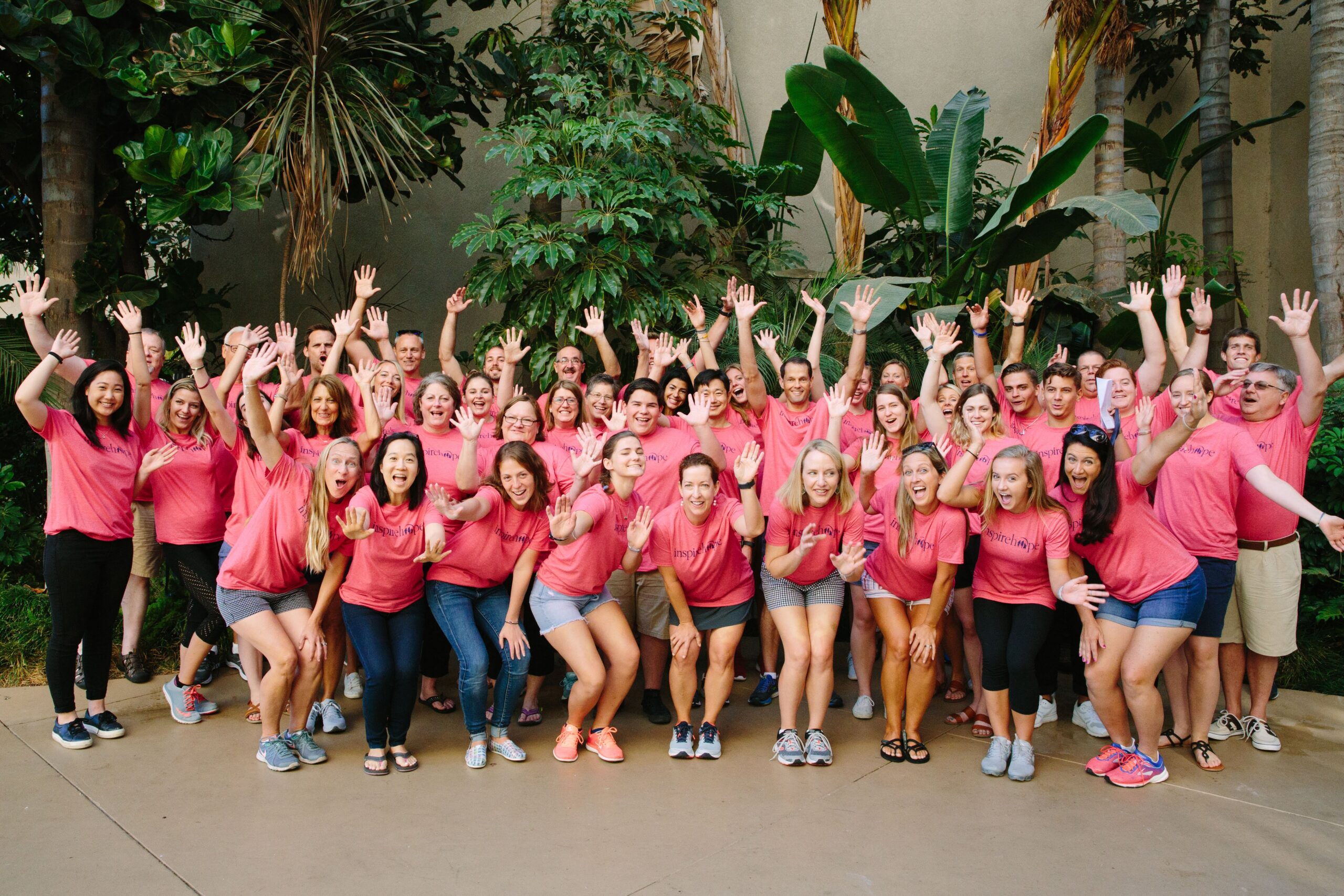 A group photo of Inheritance of Hope volunteers smiling and waving