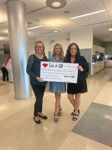 IMG_6018 (1) (1) (1) Three women smiling and holding up a large donation check