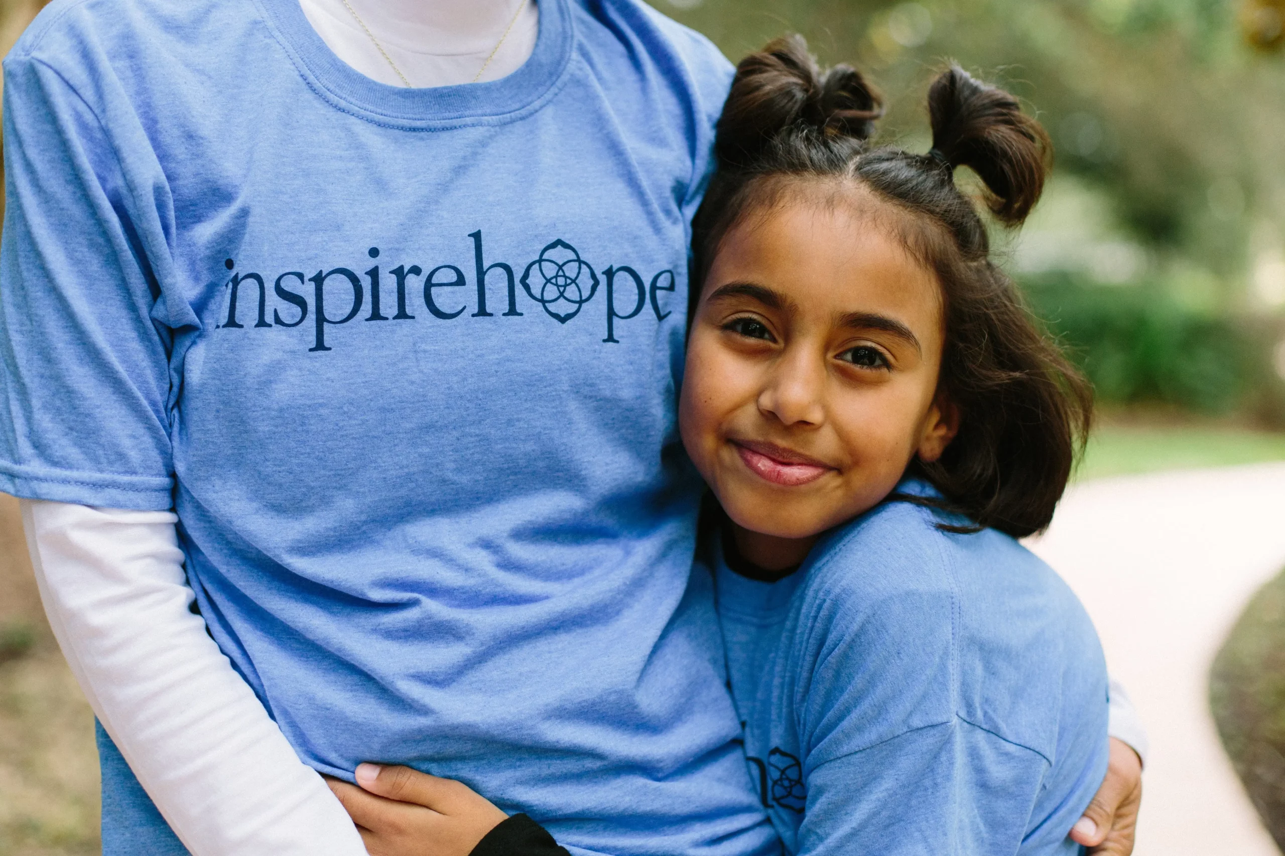 A young girl embracing her mother's waist