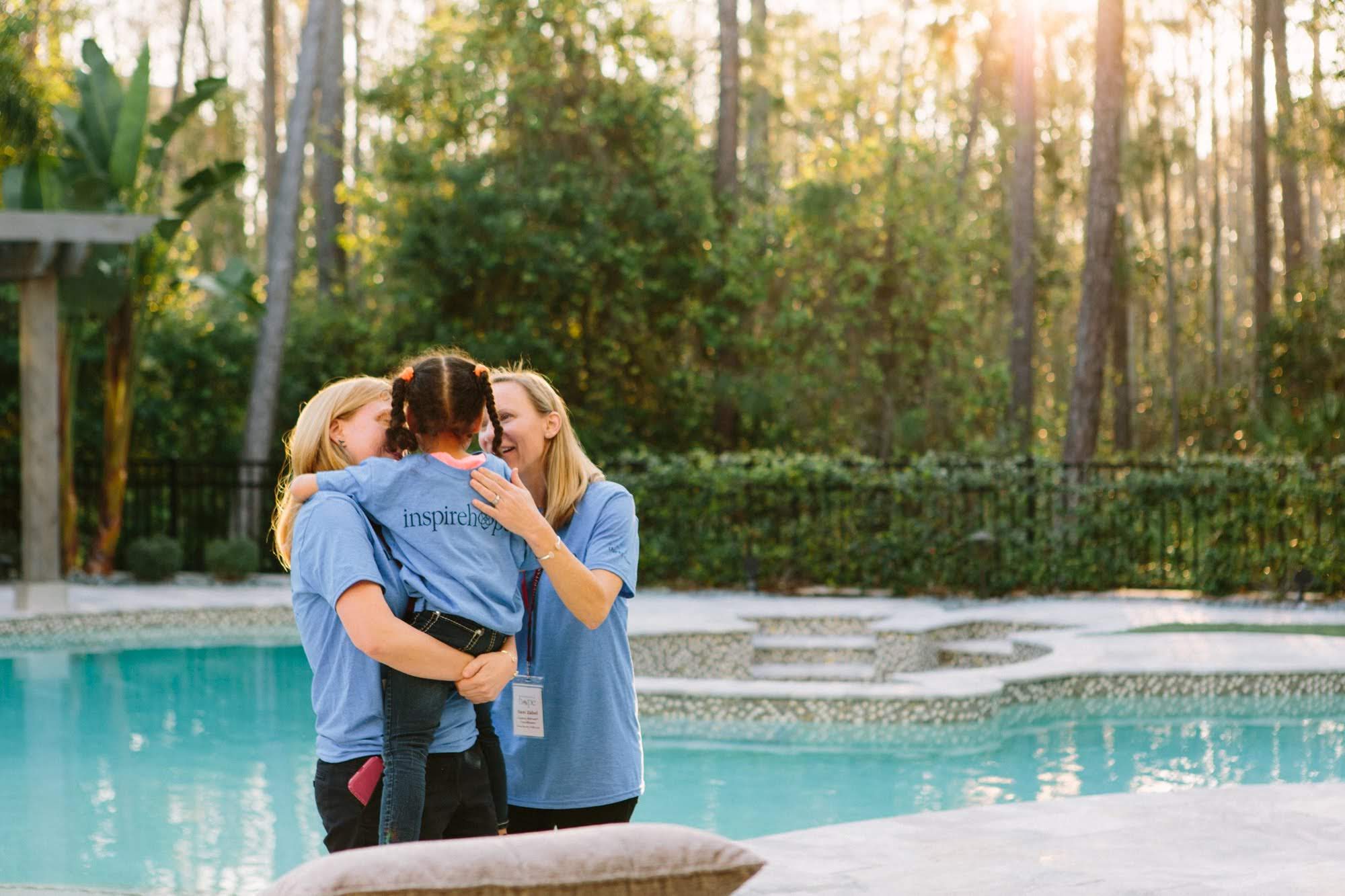 Two Inheritance of Hope volunteers comforting a young girl
