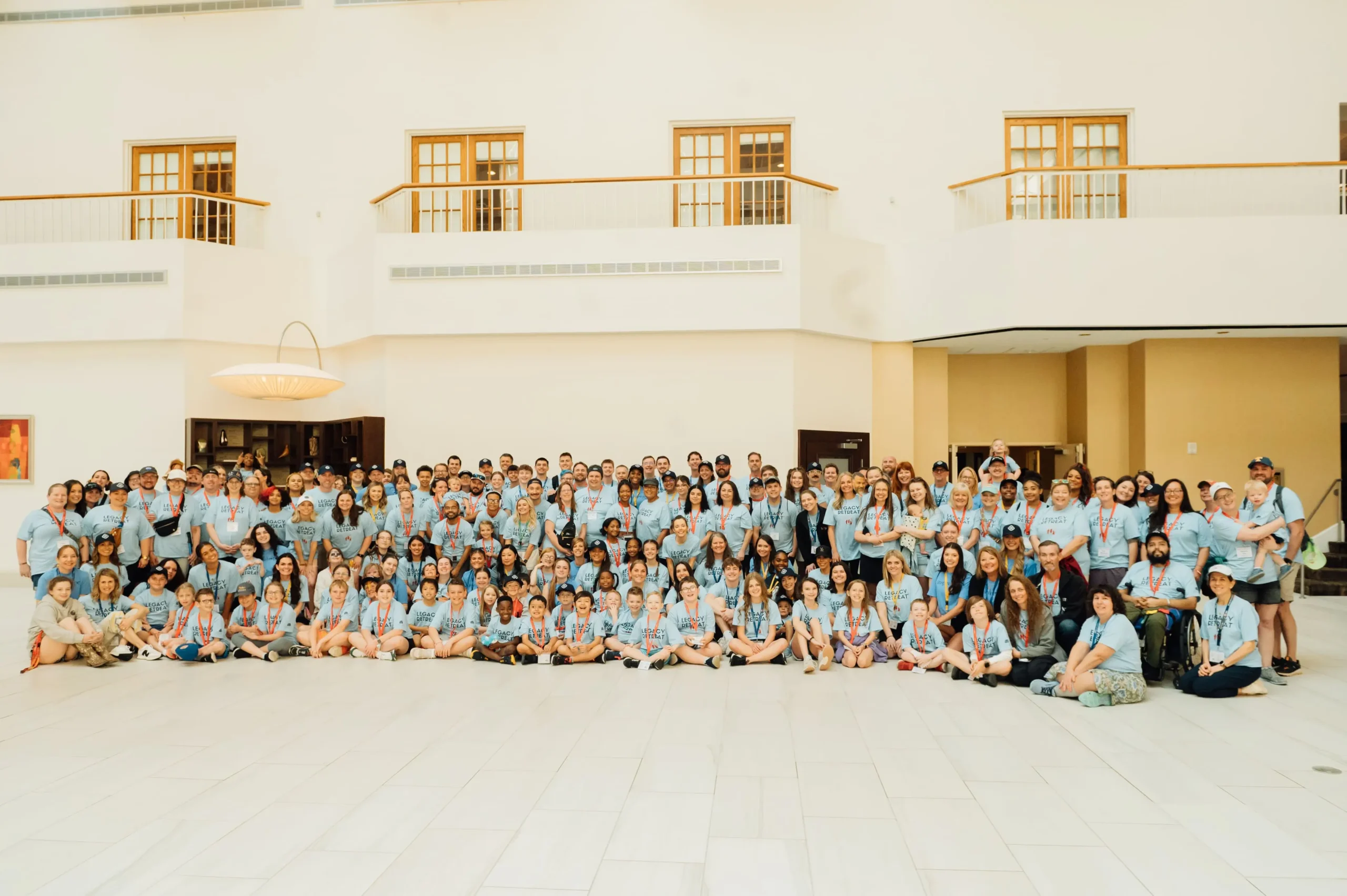 VGP_1258 (1) (1) A group photo of families and volunteers wearing blue Legacy Retreat shirts