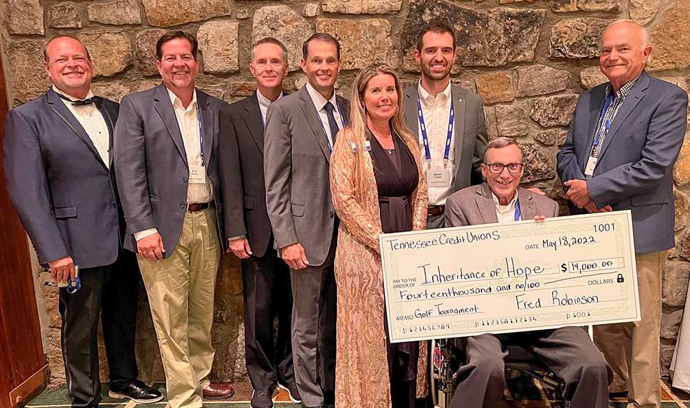 A group of Inheritance of Hope representatives posing with a $14,000 donation check