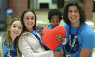 Volunteers with child holding red heart at family support charity
