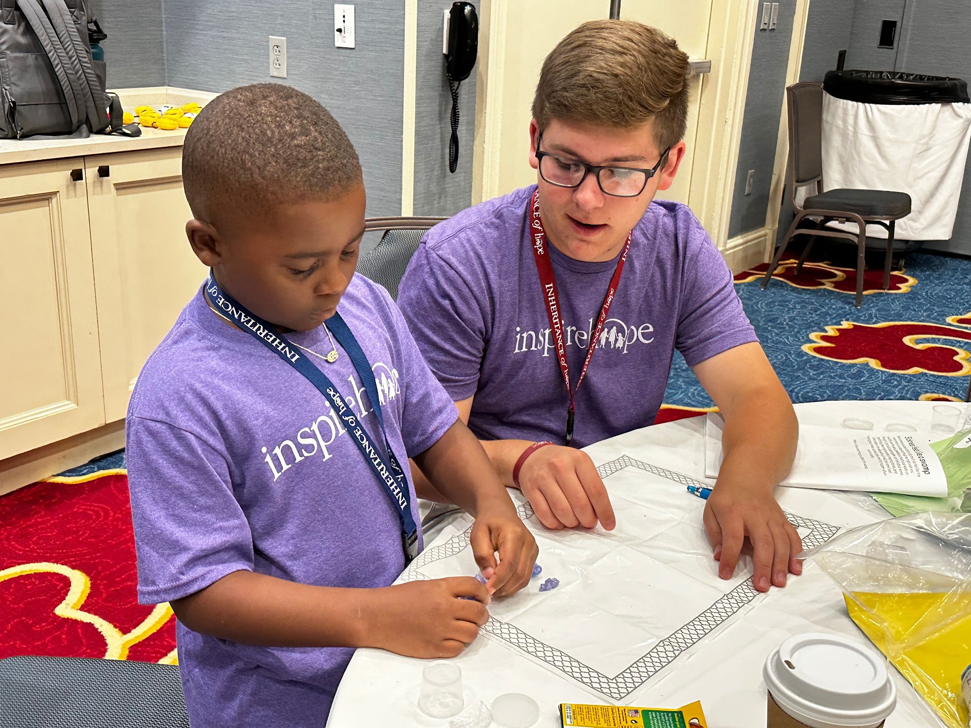 Luke Volunteering Image Luke Douglas helping kid with Legacy Session Activity.