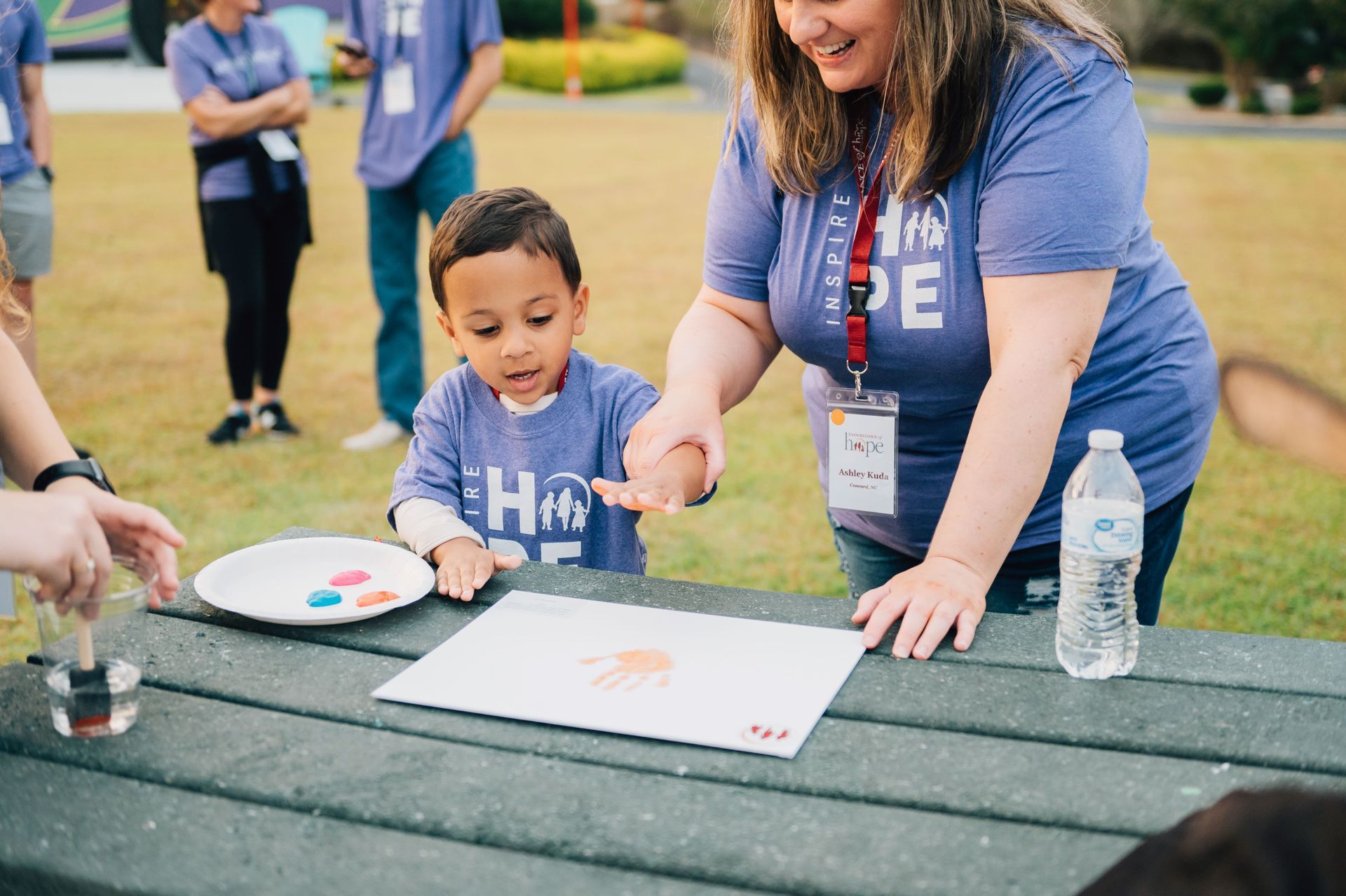 A mother and son doing a handprint craft project together.